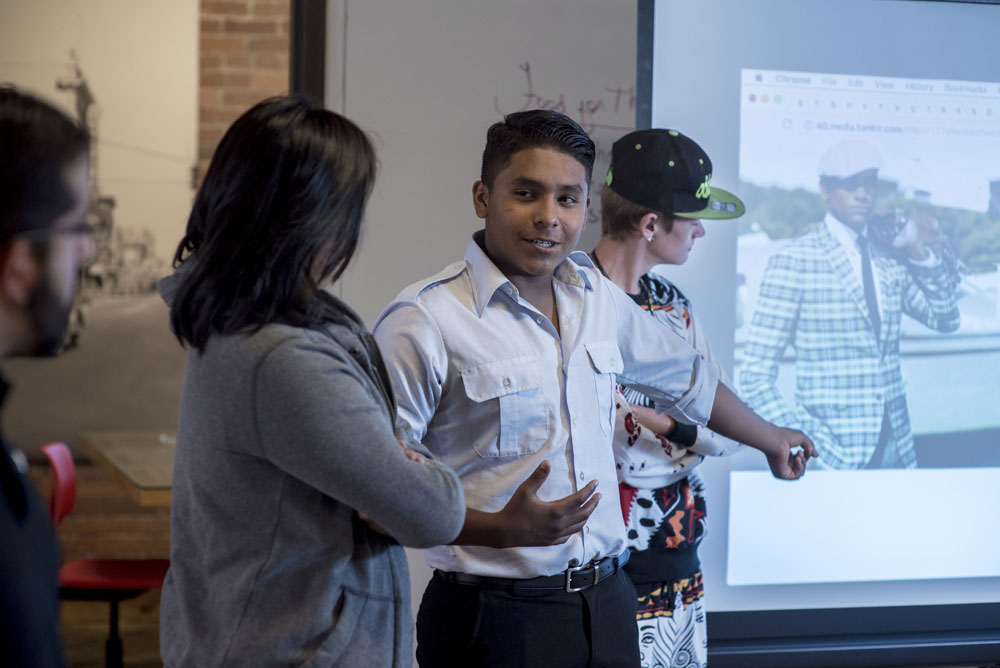 Students making a presentation in front of a projection screen.