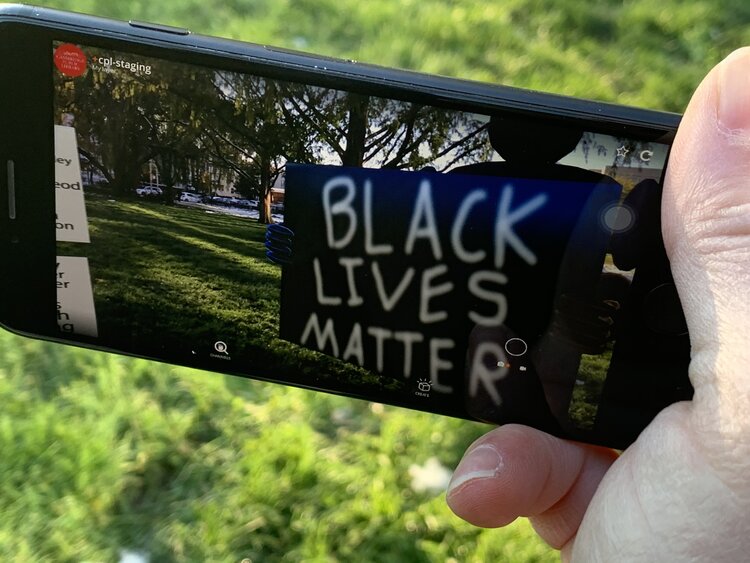 A phone taking a picture of a Black Lives Matter protest sign