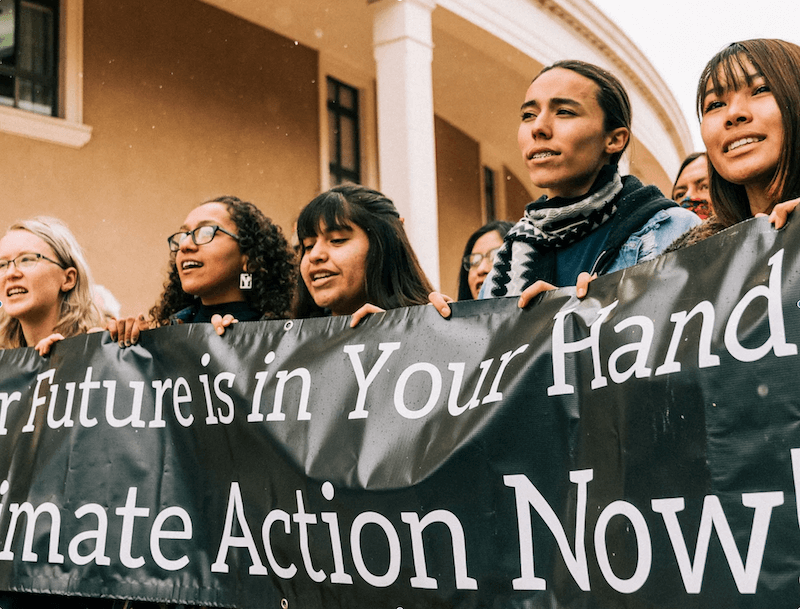 Students holding a banner demonstrating in front of the Round House