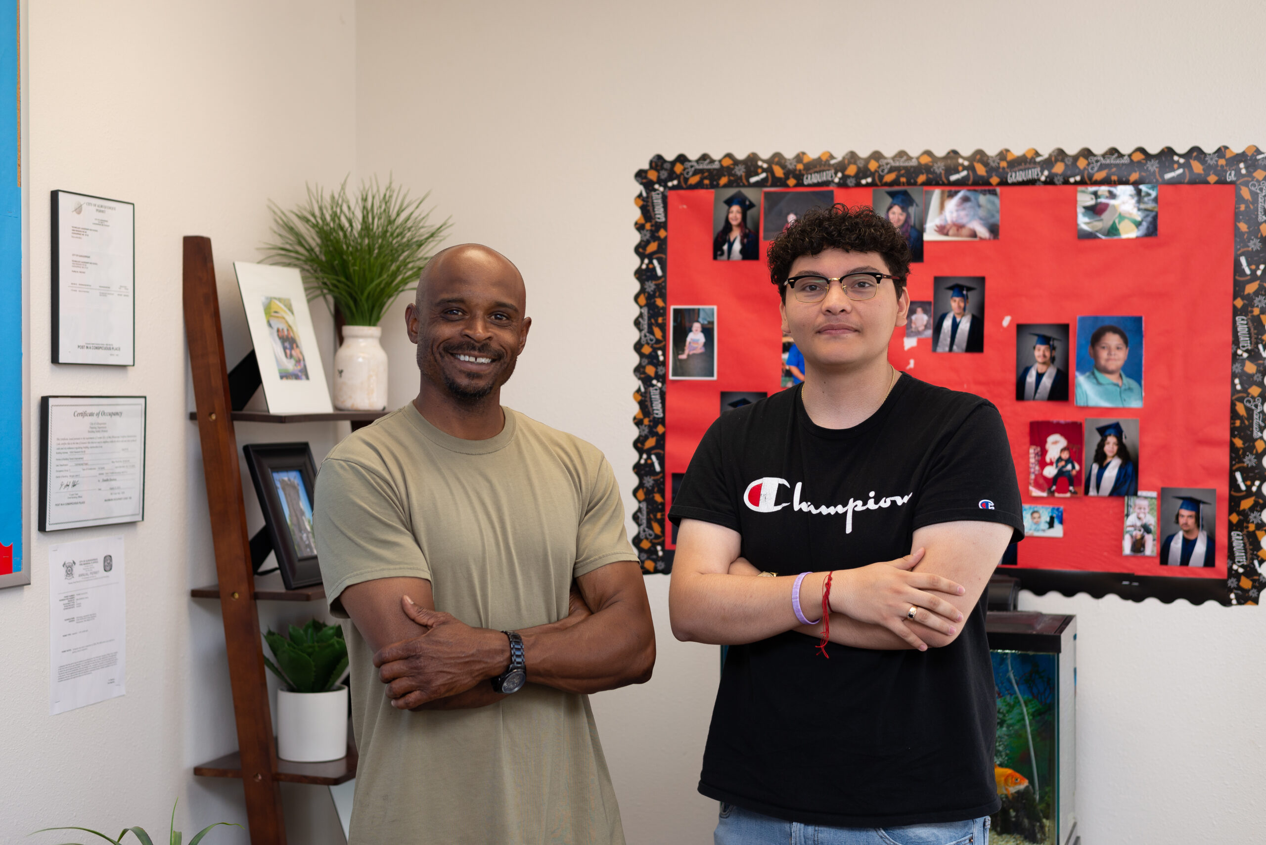 A student and teacher stand together in front of poster board.