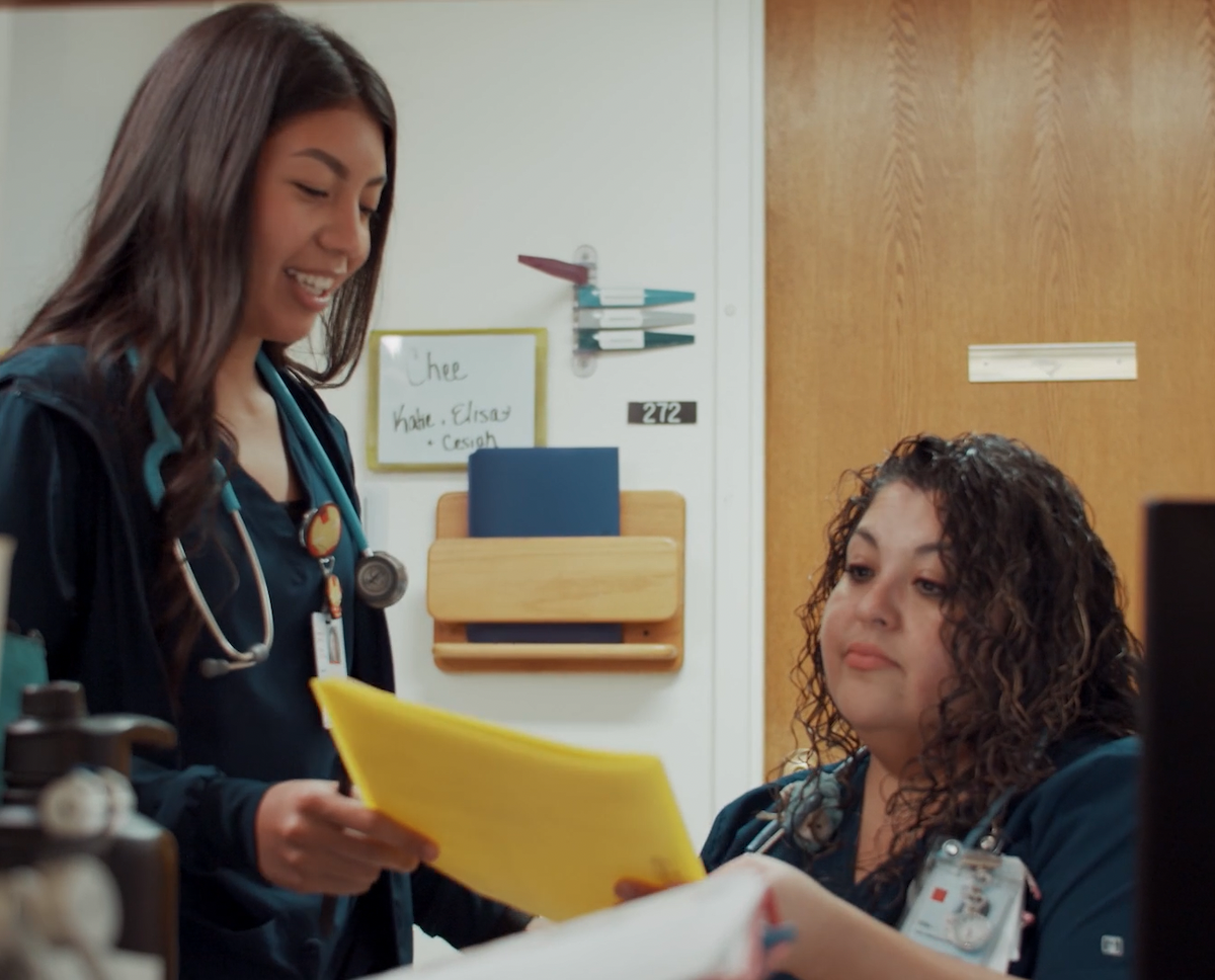 An intern at a hospital looks over paperwork with her mentor.