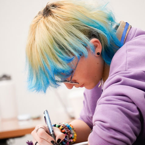 Close up of student taking notes at EdUprising 2023.