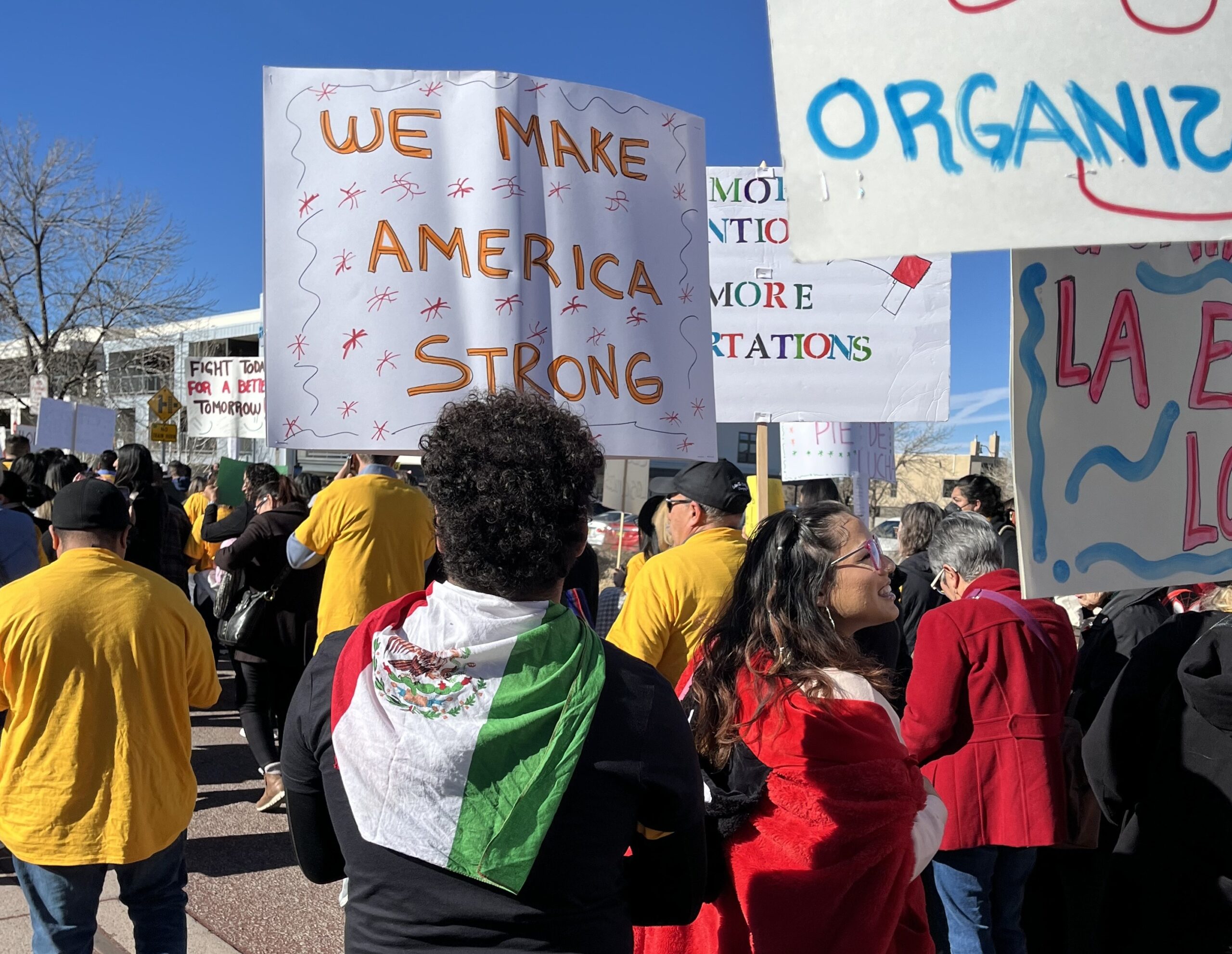 students marching with sign that says "we make America strong"